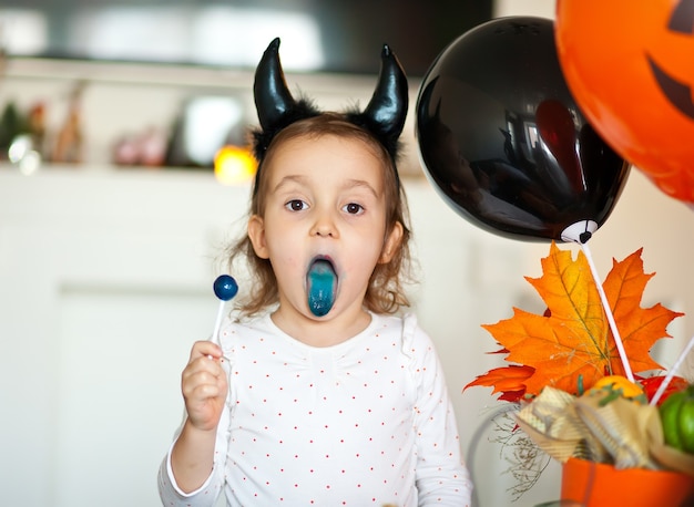 Zabawna Dziewczynka W Złym Stroju Na Halloween Jedząca Cukierki Na Patyku I Baw Się Dobrze.