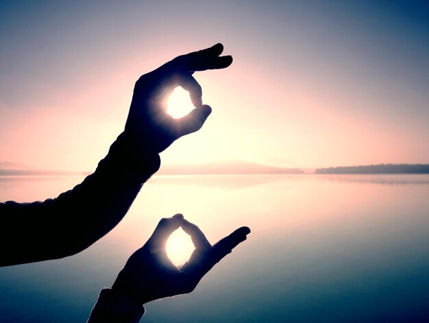 Zdjęcie zabawna gra cieni cienie ręki symbol palce gesty ramka na wschodzącym słońcu