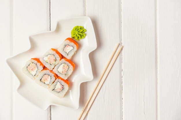 Zabawna jadalna choinka zrobiona z sushi, pomysłowy pomysł na japońską restaurację na białym stole. . wakacje, uroczystość, koncepcja sztuki żywności. Copyspace.