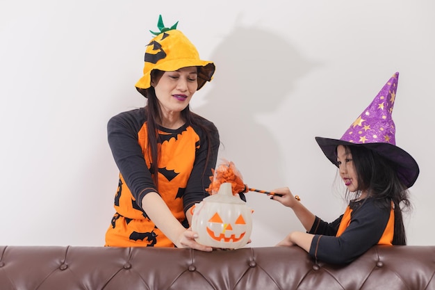 Zabawna matka i córka w stroju wiedźmy na Halloween świętują