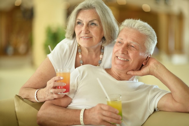 Zabawna starsza para na wakacjach pije koktajl
