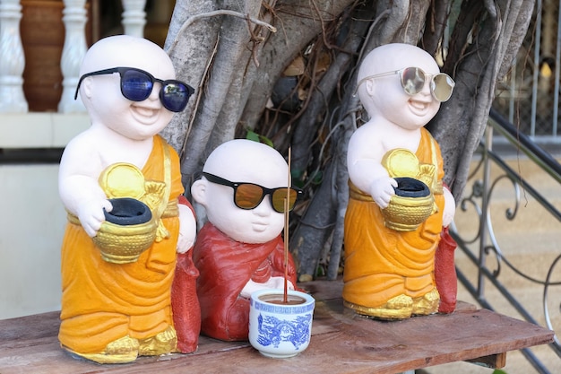 Zdjęcie zabawne buddyjskie posągi mnichów w pomarańczowych i czerwonych szatach buddyjska świątynia darowizna do świątyni