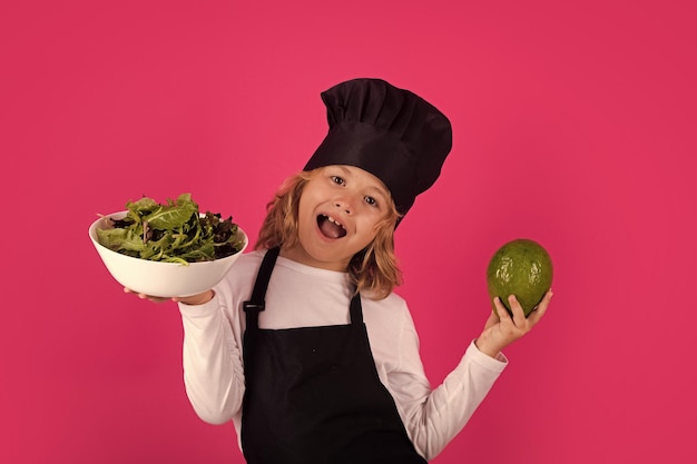 Zabawne dziecko gotujące z awokado i warzyw Chłopiec przygotowujący zdrowe jedzenie Portret dziecka z kapeluszem szefa kuchni