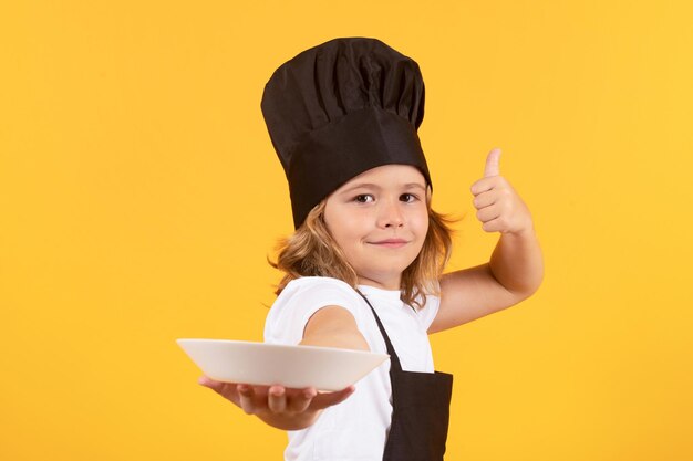 Zabawne dziecko gotuje z talerzem gotowania dzieci kucharz dziecko chłopiec w postaci kucharza dziecko chłopiec z