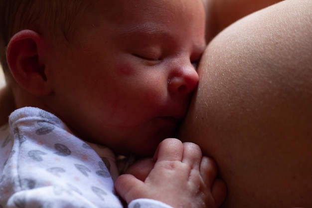 zabawne noworodek zasypia na piersi matki po ssaniu