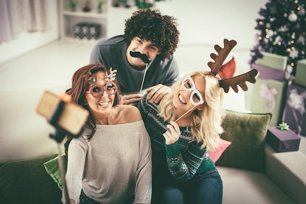 Zabawni przyjaciele pozują do selfie podczas świątecznego święta.