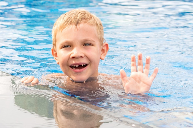 Zabawny chłopak, pływanie i gra w basenie