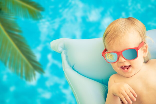 Zabawny chłopczyk na letnie wakacje. Dziecko bawiące się w basenie