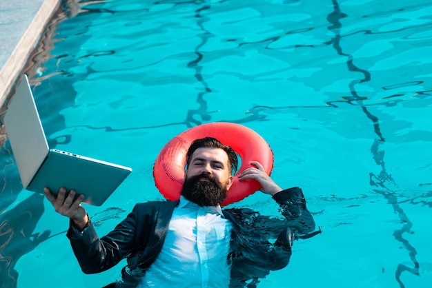 Zabawny człowiek biznesu relaks w garniturze na basenie