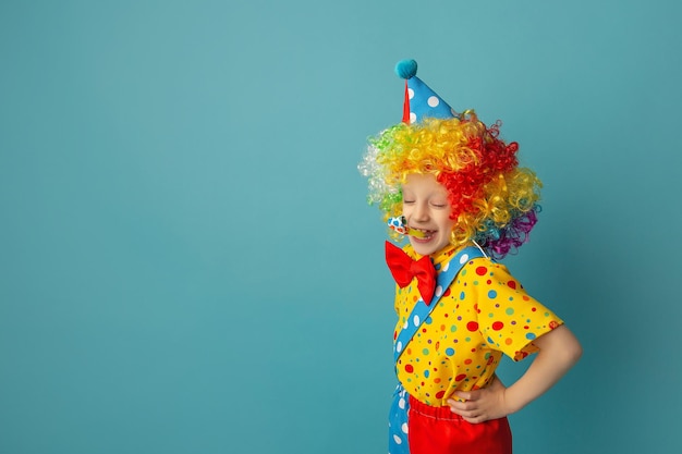 Zabawny klaun dla dzieci na niebieskim tle Szczęśliwe dziecko bawiące się świątecznym wystrojem 1 April Fool's day