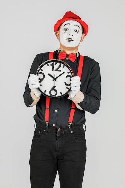 Zabawny klaun z zegarem na białym tle