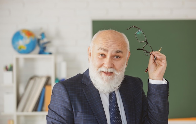 Zdjęcie zabawny profesor w szkole nauczyciel uśmiechający się w klasie