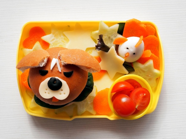 Zabawny pysk psa wykonany z hamburgera w pudełku na lunch. Zabawna sztuka kulinarna dla dzieci