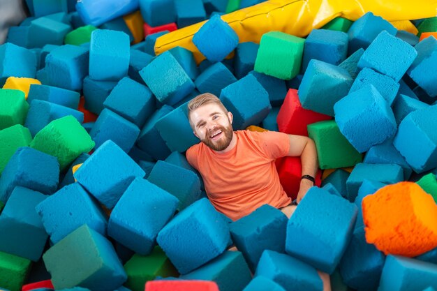 Zabawny szczęśliwy człowiek bawiący się na trampolinie w pomieszczeniu