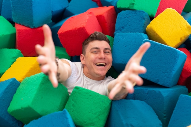 Zdjęcie zabawny szczęśliwy człowiek bawiący się na trampolinie w pomieszczeniu