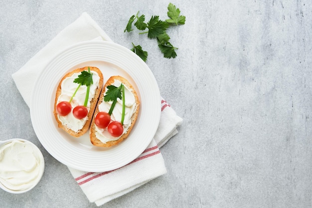 Zabawny toast w kształcie dojrzałych wiśni kanapka z serem śmietanym chleb wiśnia pomidor cebula i pietruszka idea sztuki żywności dla dzieci jedzenie kreatywne śniadanie widok z góry kopiować przestrzeń