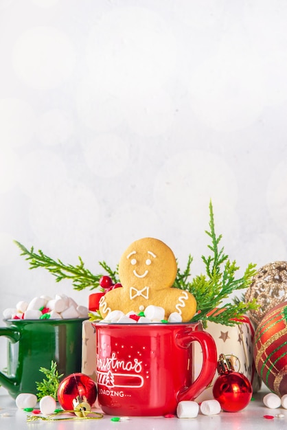 Zabawny, uroczy piernikowy ludzik w gorącej czekoladzie cappuccino lub latte Świąteczny świąteczny kubek kakaowy z pianką i ciastkiem z wystrojem choinki na białym tle bokeh