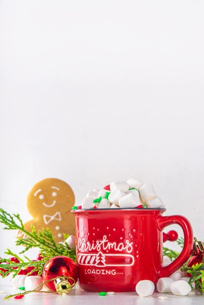 Zabawny, uroczy piernikowy ludzik z gorącą czekoladą cappuccino lub latte Świąteczny świąteczny kubek kakaowy z pianką i ciastkiem z wystrojem choinki na białym tle bokeh