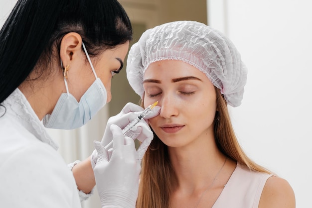 Zabieg kosmetyczny wypełniający bruzdę nosowo-łzową i mezoterapię wokół oczu dla młodej pięknej dziewczyny Nowoczesna kosmetologia