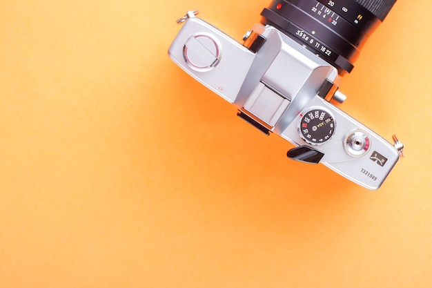 Zabytkowy aparat filmowy 35 mm na pomarańczowym tle