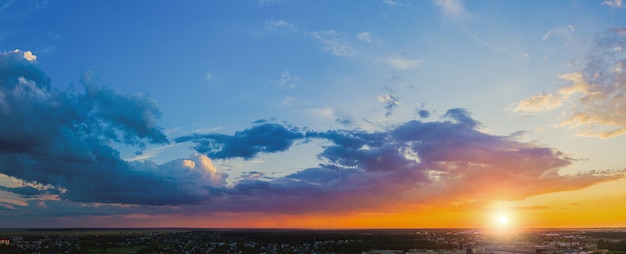 Zachmurzony krajobraz o zachodzie słońca. Wieczorna panorama nieba