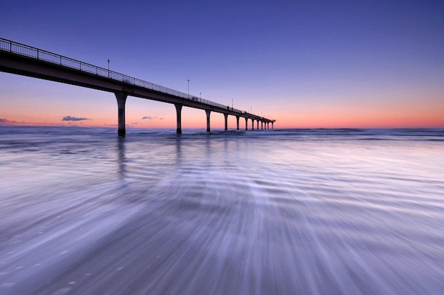 Zachód słońca i przepływ fal w New Brighton Pier Christchurch w Nowej Zelandii