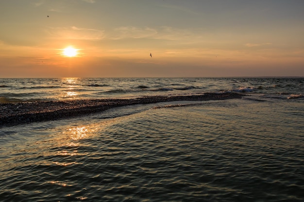 Zachód słońca na horyzoncie wieczorem plaży morskiej