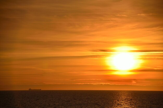 Zachód słońca na morzu ze statkiem