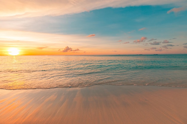 Zachód słońca na plaży. Piękny panoramiczny krajobraz, kolorowy złoty zachód słońca nad spokojnym morzem z falami surf