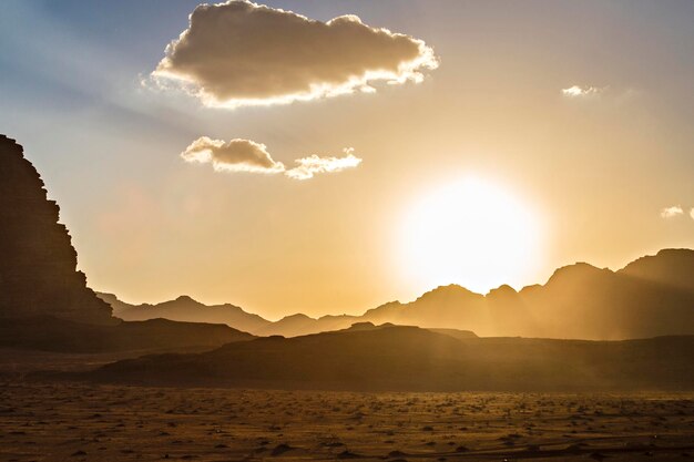 Zachód słońca na pustyni Wadi Rum. Pomarańczowy zachód słońca niebo i chmury w Wadi Rum, Jordania