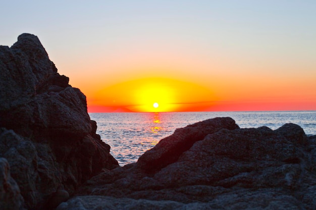Zachód słońca na skalistym brzegu. Morze Tyrreńskie zachód słońca w Kalabrii, Włochy.