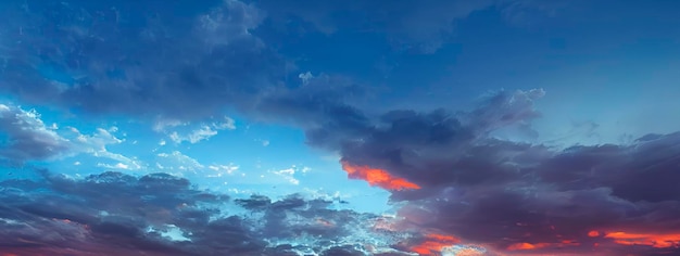 Zachód słońca na wieczornym niebie z niebieskimi i pomarańczowymi chmurami