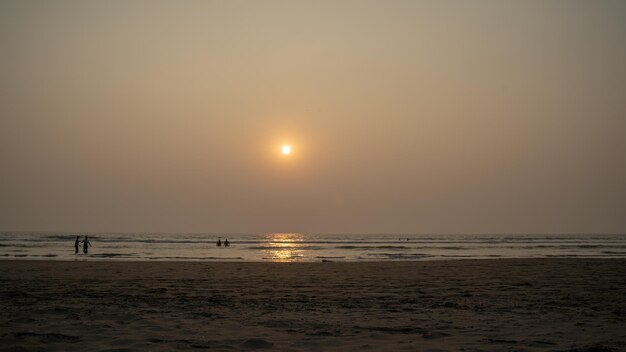 Zachód słońca nad morzem i plażą Bezchmurne niebo o zachodzie słońca nad falującym morzem i piaszczystą plażą wieczorem w ośrodku
