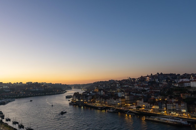 Zachód słońca nad rzeką Douro i oświetlone miasto Porto