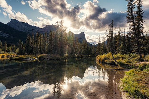 Zachód Słońca Nad Skalistą Górą Z Odbiciem Lasu Sosnowego Na Stawie W Canmore Alberta, Kanada