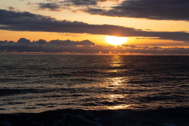 Zachód słońca nad wodą z ptakami latającymi przeciwko światłu słonecznemu na Morzu Śródziemnym