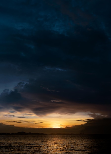 Zachód słońca Niebo o zmierzchu wieczorem z pomarańczowym żółtym i ciemnoniebieskim kolorem nad morzem Wybrzeże z dramatycznym krajobrazem zmierzchu Skyline i chmurą Pionowy romantyczny wschód słońca latem