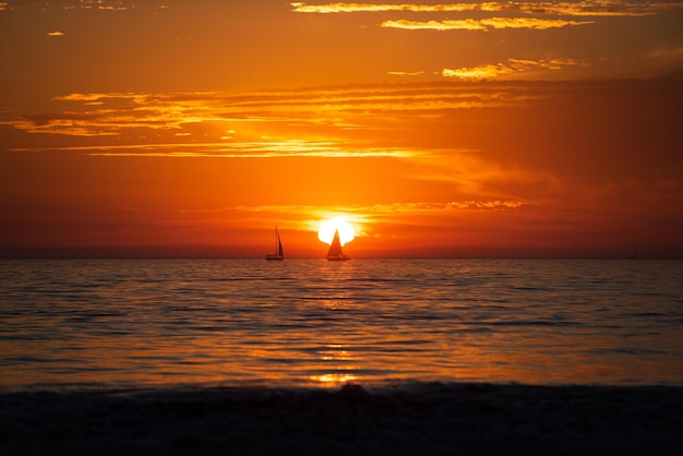 Zachód słońca sylwetka żaglówkę. Morze plaża z zachód słońca niebo streszczenie tło. Skopiuj miejsce koncepcji wakacji i podróży.