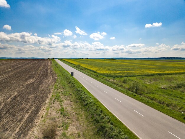 Zachód słońca w chmurach z promieniami słońca nad drogą do horyzontu widok z góry