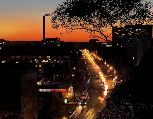 zachód słońca w mieście widok z okna noc drzewo cień światła ruchu samochodowego