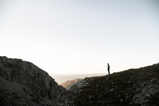 Zdjęcie zachód słońca w picos de europa pico urriellu z turystą patrzącym w horyzont