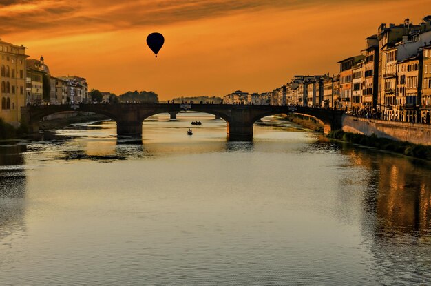 Zachód słońca we Florencji nad mostem na rzece Arno, Toskania, Włochy.