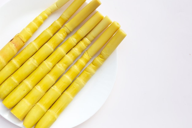 Zachowane pędy bambusa w białej misce na żółtym tle
