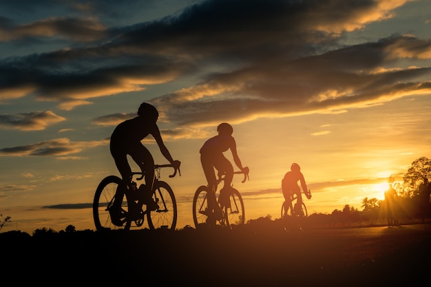 Zdjęcie zadek cykliści jeździć na rowerze na zachód czas tło