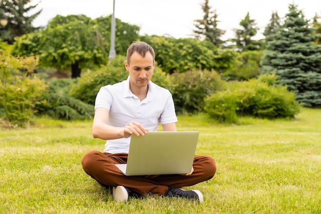 Zadowolony biznesmen pracuje na laptopie z internetem bezprzewodowym.