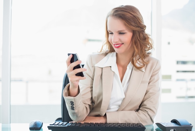 Zadowolony ładny Bizneswoman Patrzeje Jej Telefon Komórkowego