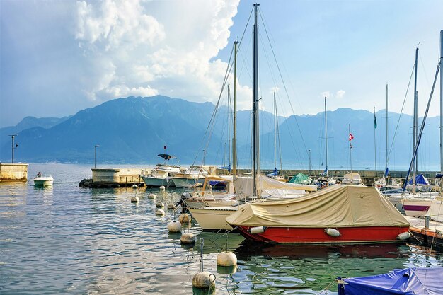 Żaglówki w przystani na Jeziorze Genewskim w Vevey, kanton Vaud, Szwajcaria. Ludzie w tle