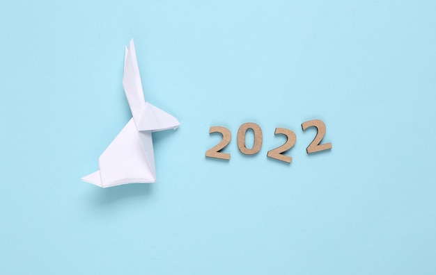 Zdjęcie zajączek origami i 2022 na niebieskim tle