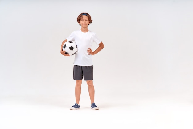 Zajęcia Sportowe Pełnometrażowe Ujęcie Szczęśliwego Nastoletniego Chłopca Trzymającego Piłkę Nożną Patrzącego Na Kamerę I