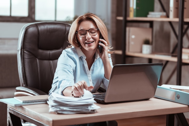 Zajęty bizneswoman. Zajęta atrakcyjna doświadczona bizneswoman rozmawiająca przez telefon ze swoim partnerem